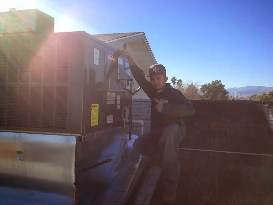 HVAC technician performing Air Duct Cleaning on a rooftop unit in East Caln